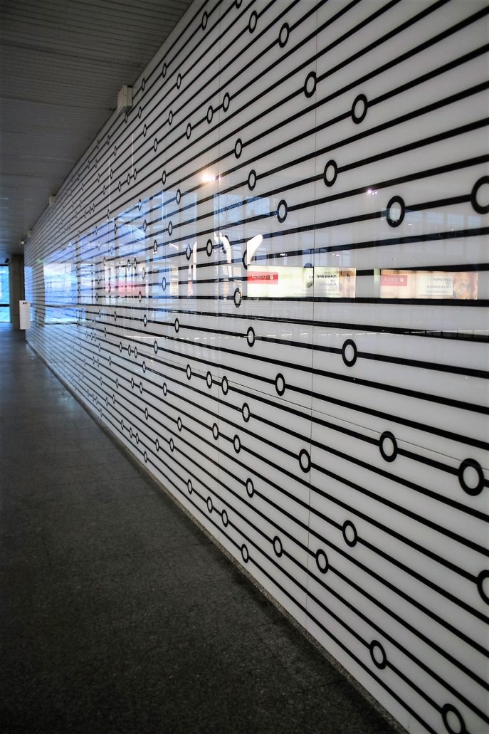 Szklany panel na ścianie starej antresoli. Identyczne panele zastosowane zostały w zmodernizowanym w 2015 r. korytarzu zachodnim pod Al. Jana Pawła II. Fot. Jerzy S. Majewski